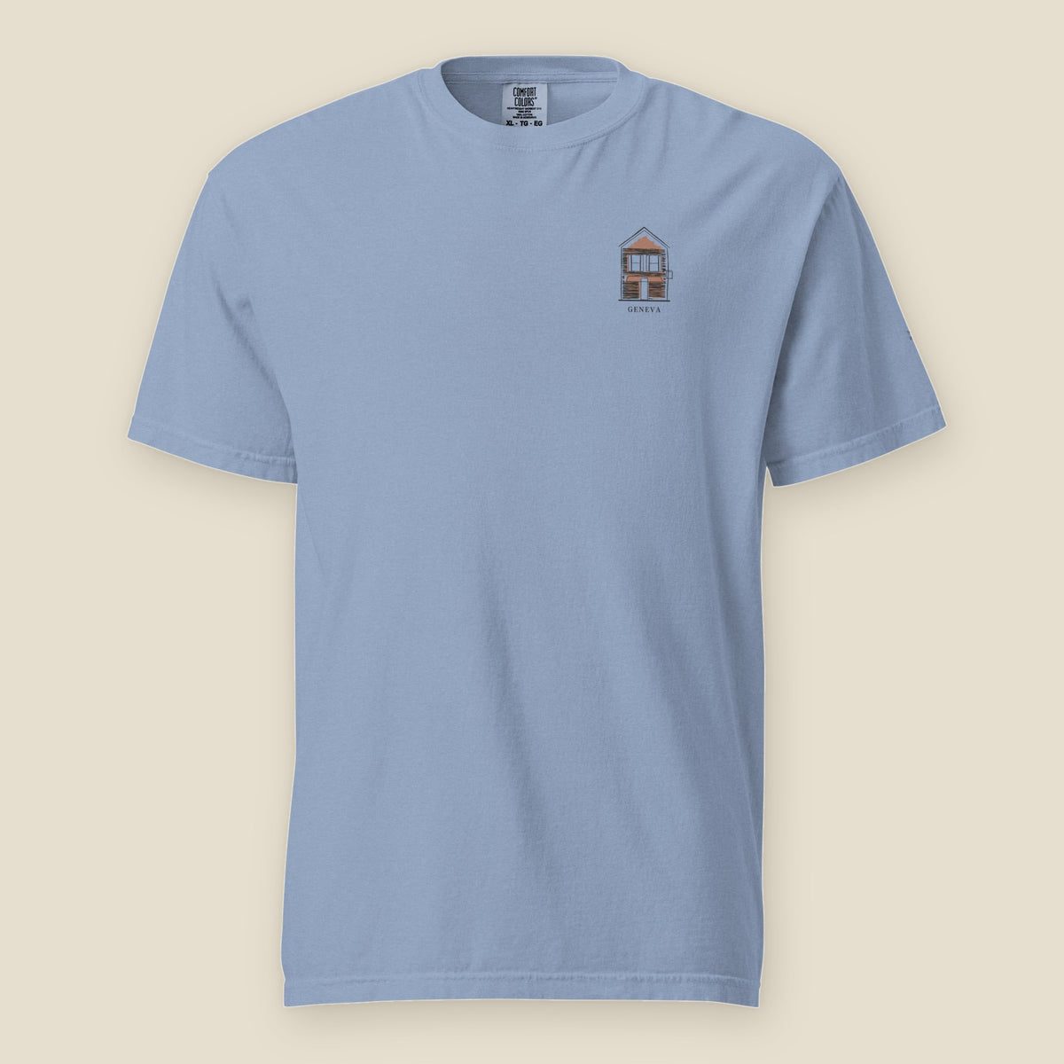Geneva Tee, front, Washed Denim: a red-sided cottage over GENEVA at the left chest