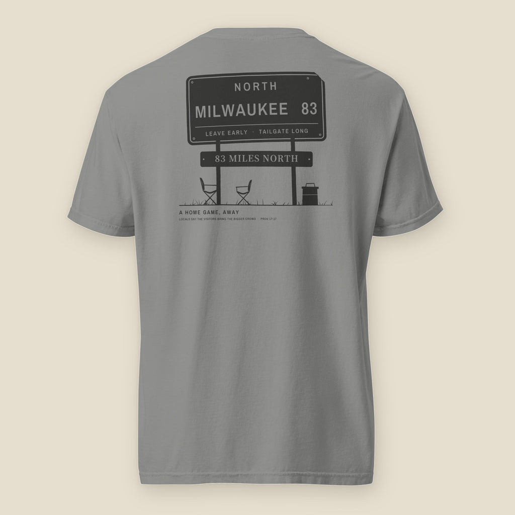 83 Miles North Tee, back, Grey: highway sign reading NORTH, MILWAUKEE 83 over two camp chairs and a cooler