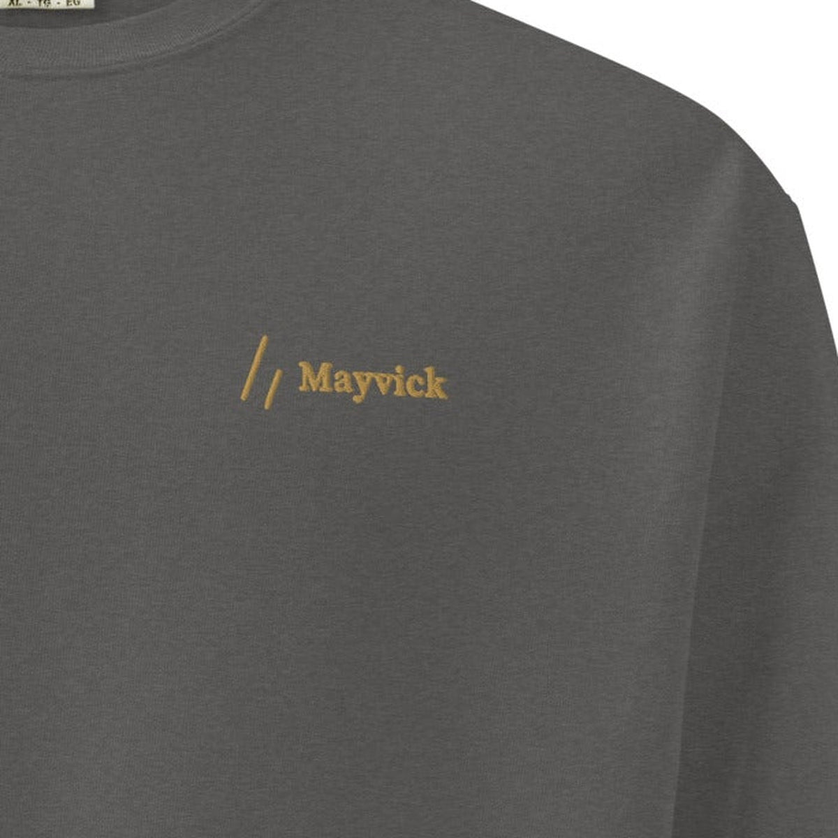 Crewneck, chest close-up, Pepper: the double slanted line mark and Mayvick stitched in Old Gold.
