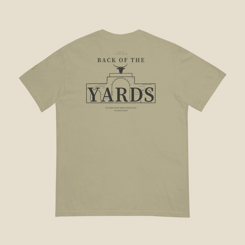 Back of the Yards Tee, back, Prairie Path (Khaki): the mark and 1 COR 10:31 small at the neck over BACK OF THE YARDS, the line-drawn gate and bull's head behind YARDS, THE UNION STOCK YARDS CLOSED IN 1971 / THE GATE STAYED below
