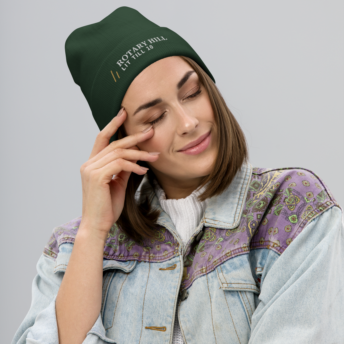 Rotary Hill Beanie, worn, three-quarter, Dark Green: ROTARY HILL in white and the Old Gold mark