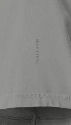 83 Miles North Tee, left sleeve close-up: North on 94 printed tone on tone