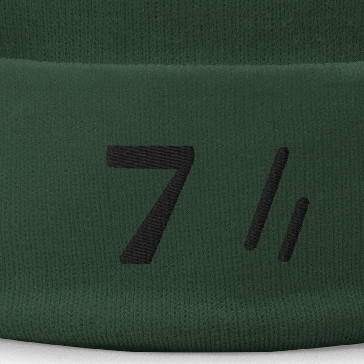 Mayvick Knit Beanie 7, cuff close-up, Dark Green: the bold 7 and the double slanted line mark in black.