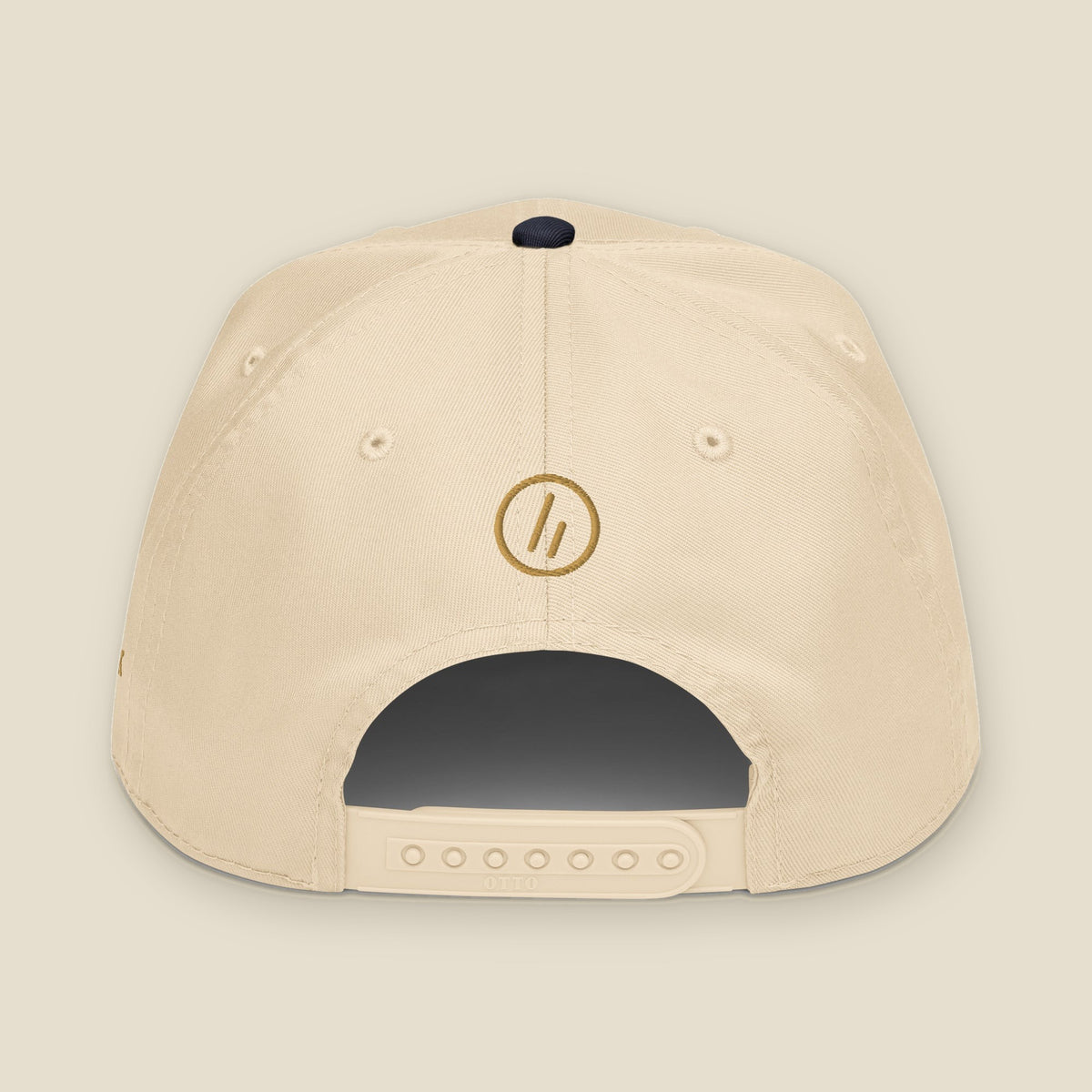 Mayvick Structured Cap, back, Natural/Navy: the Old Gold stitched roundel symbol above the closure.