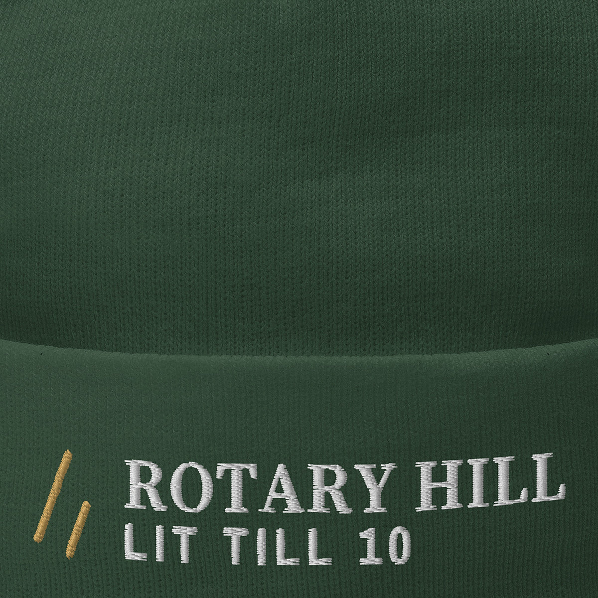 Rotary Hill Beanie, mark close-up, Dark Green: ROTARY HILL over LIT TILL 10 and the Old Gold mark.