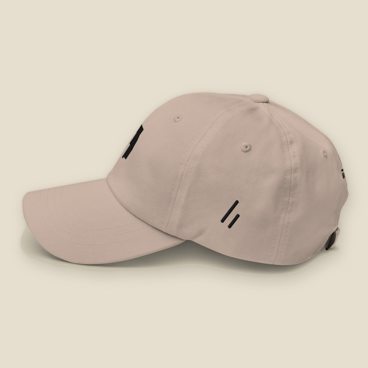 Six County Dad Hat, left side, Stone: the double slanted line mark stitched small in black.
